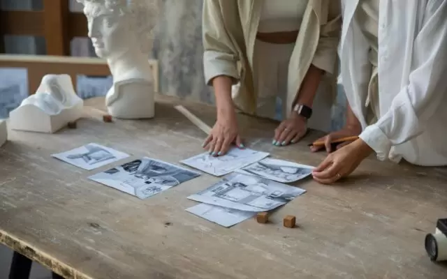 Pencil Drawings on Wooden Table and Women Hands